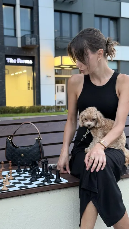 Vibe Chess in Moscow: A chess board on a bench, one of the players with her dog