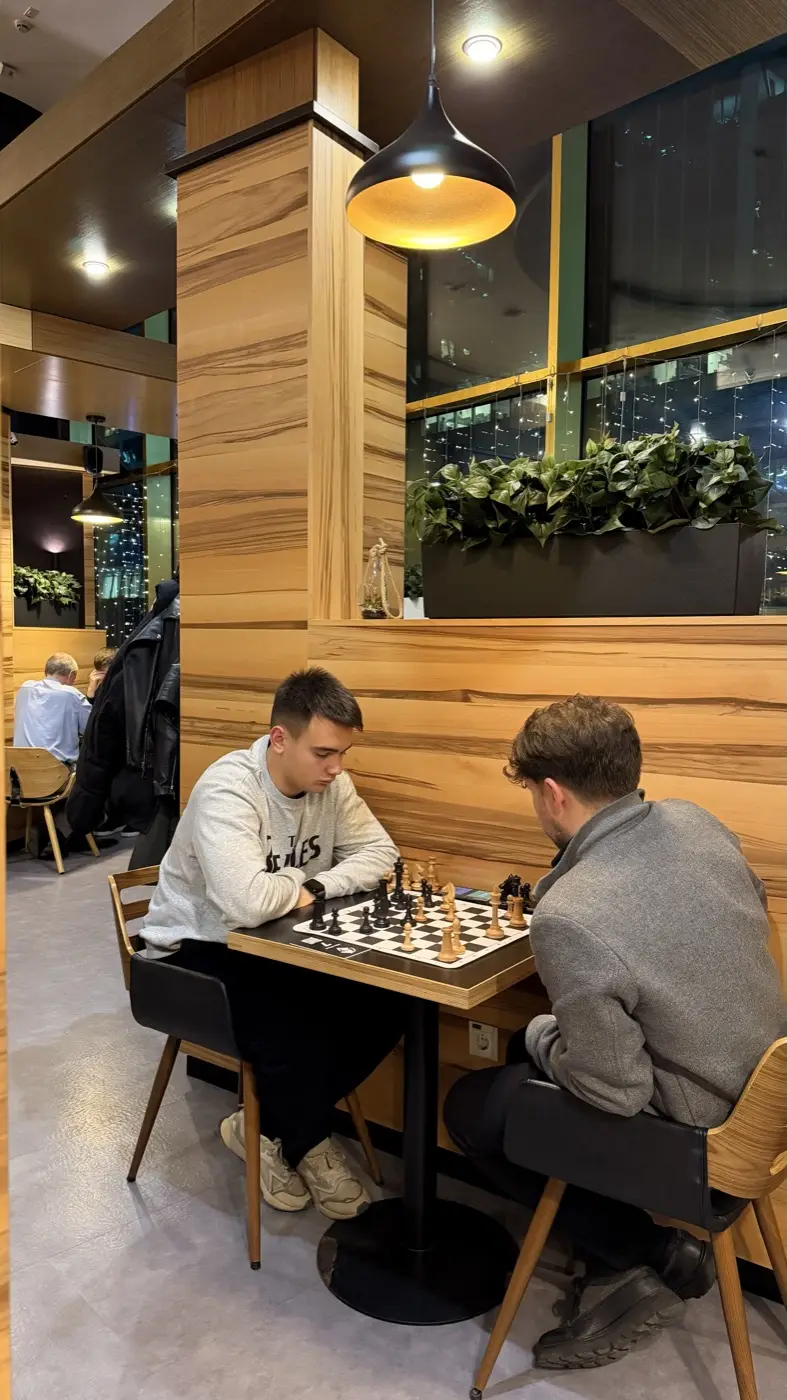 A game at a table by the window, the lights of Moscow City behind the glass