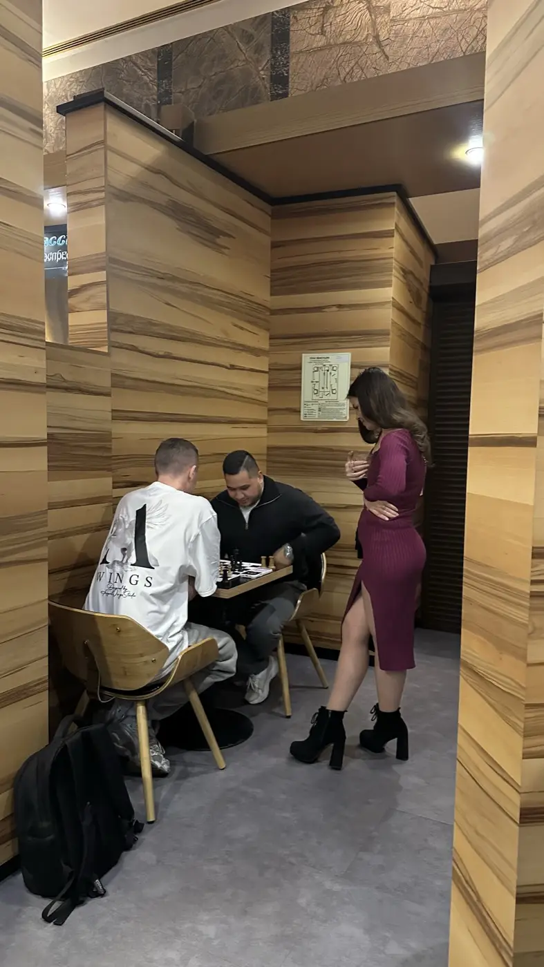 Two people playing a game while a spectator stands and watches