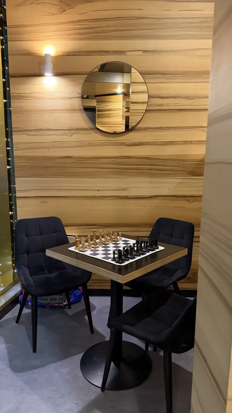 A table with a chessboard in the corner of the coffee shop by a floor-to-ceiling window