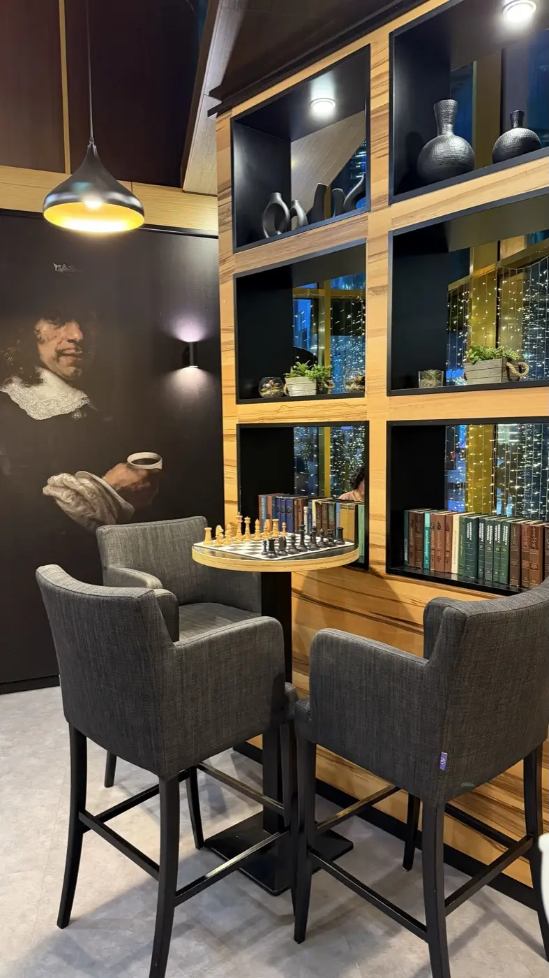A chess table against a wall with a painting and bookshelves