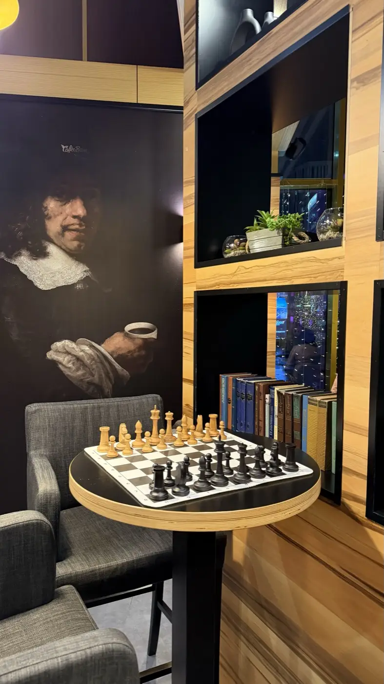Pieces set up on a small round table next to a bookcase