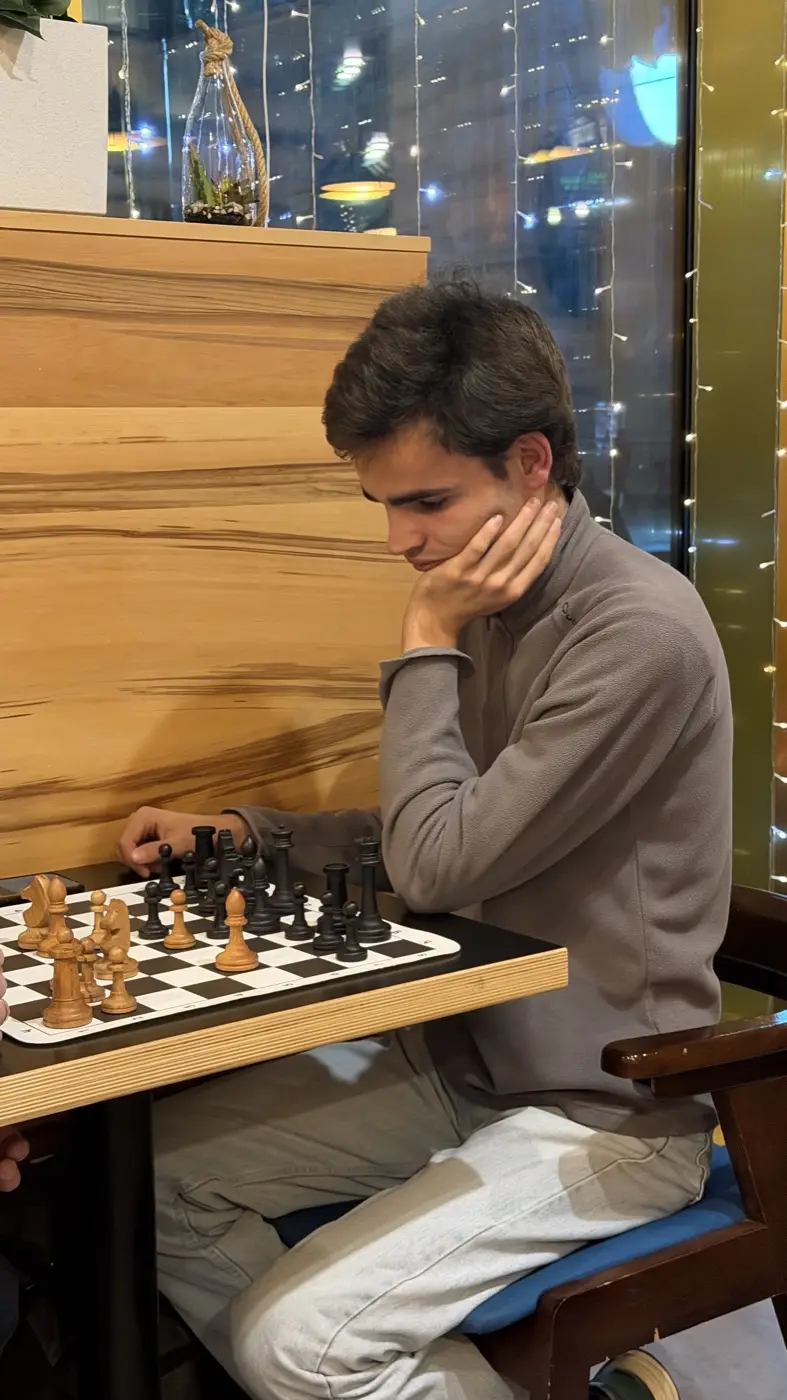 A player thinking over a move above a board with wooden pieces