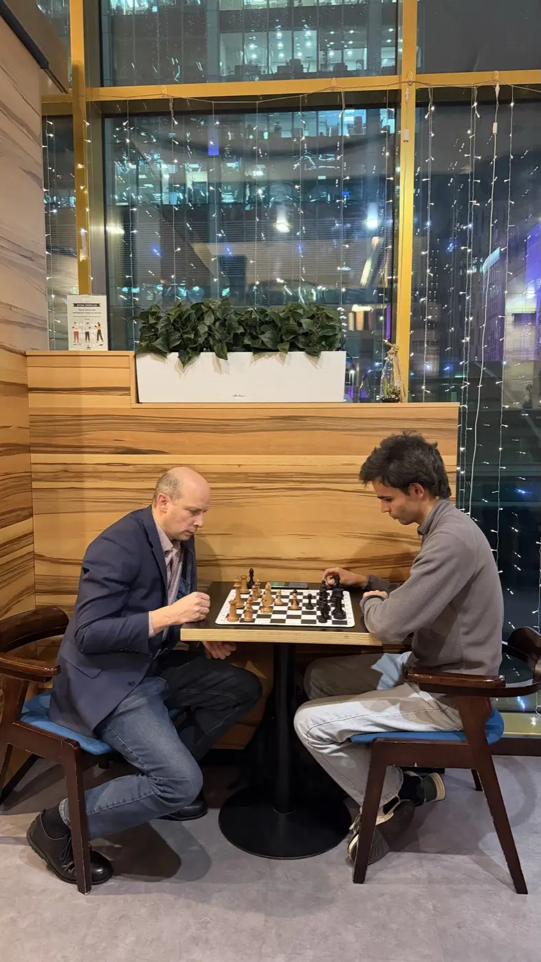 Chess in Moscow City: two people playing a game at a table in Coffee Bean