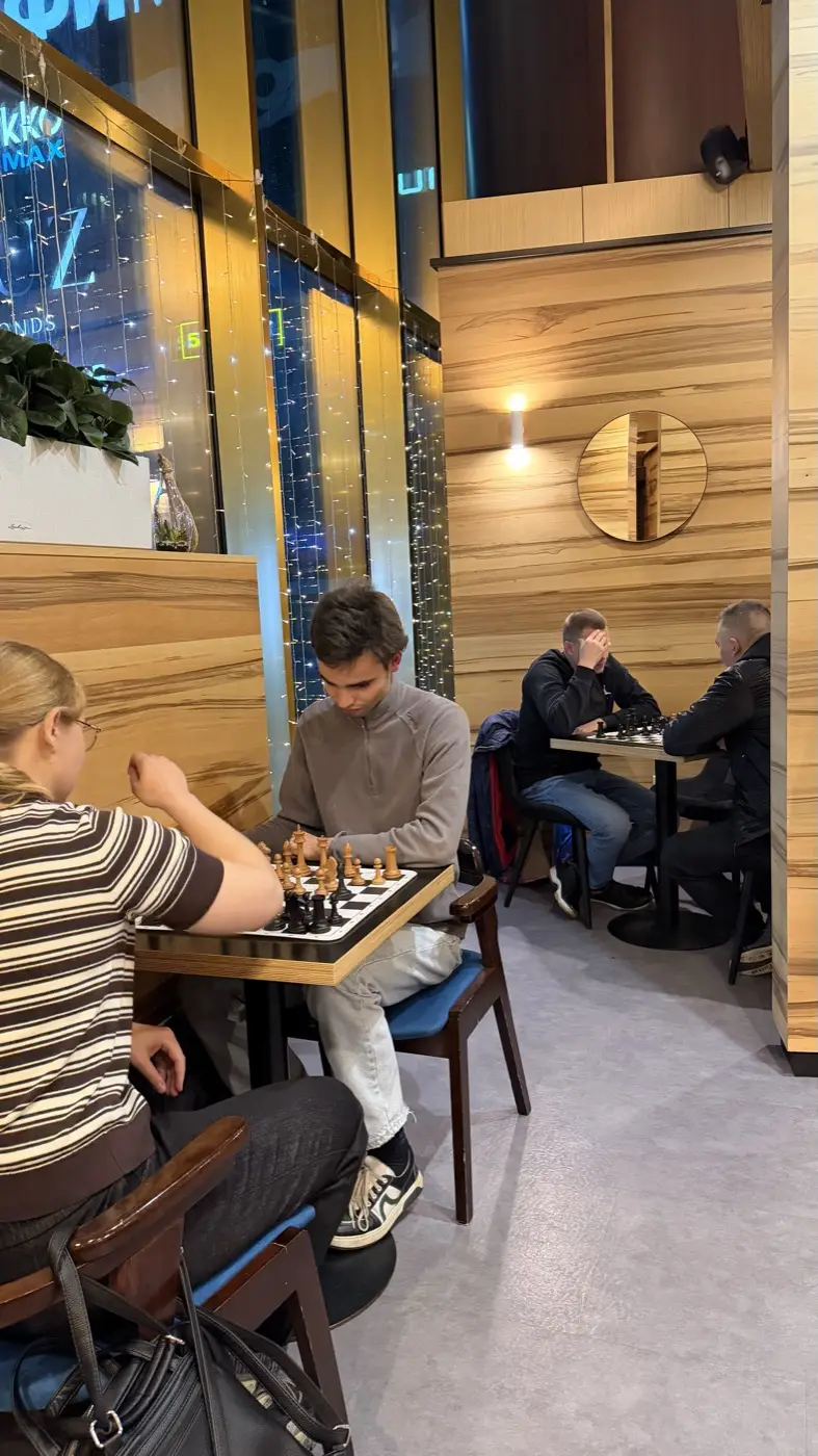 Games at two tables in Coffee Bean, with the lights of the Moscow City towers outside the window