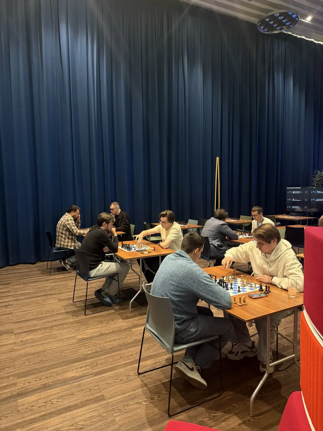Players at a corporate chess tournament in an office hall