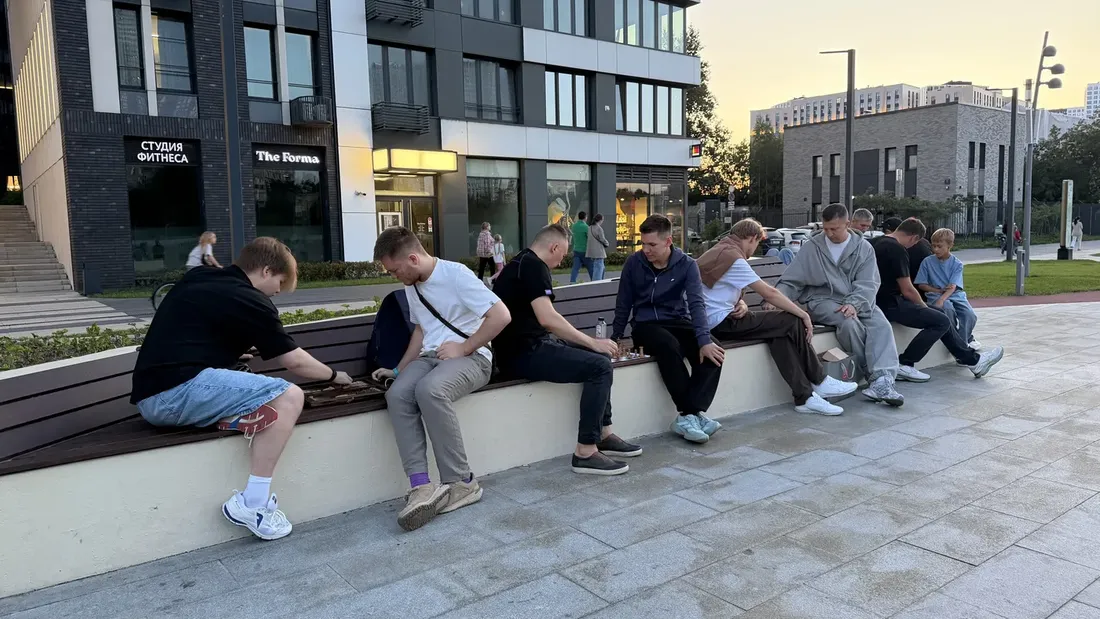 A group playing chess on the Moscow embankment in the evening