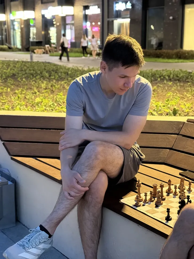 Two people playing chess by the river at sunset